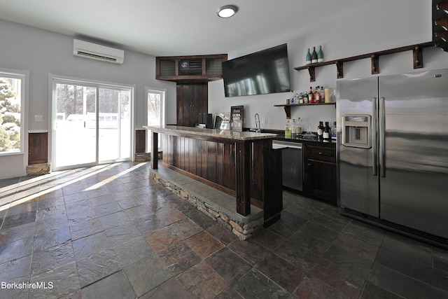 kitchen featuring stone tile floors, a sink, appliances with stainless steel finishes, a wall mounted AC, and open shelves