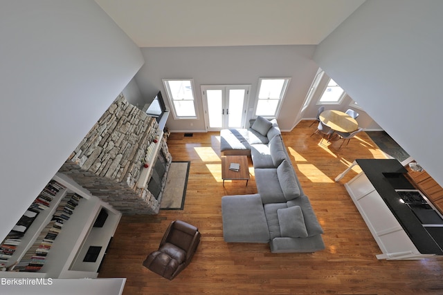 living room featuring french doors, baseboards, and wood finished floors