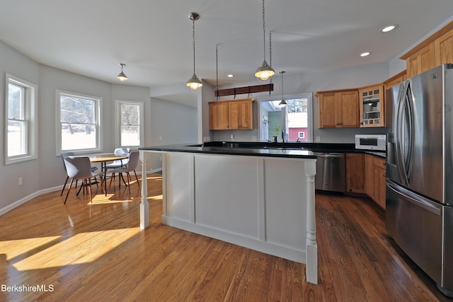 kitchen featuring brown cabinets, stainless steel appliances, and dark wood-type flooring