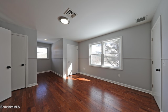 unfurnished bedroom featuring baseboards, visible vents, and hardwood / wood-style floors