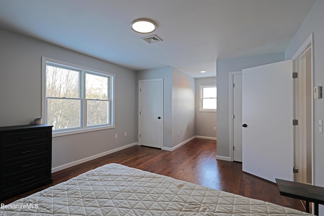 bedroom featuring visible vents, baseboards, and wood finished floors