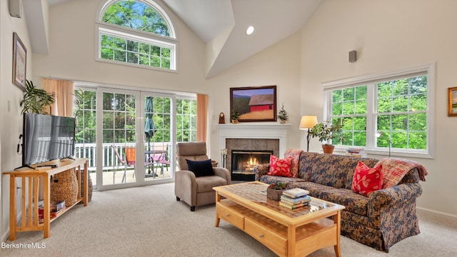 9074 Mountainside Dr, Hancock, MA 01237 - carpeted living room featuring high vaulted ceiling, a tiled fireplace, and baseboards