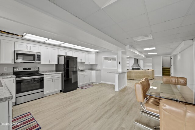 73 Narragansett Ave, Lanesborough, MA 01237 - kitchen featuring stainless steel appliances, open floor plan, light wood-type flooring, white cabinets, and a paneled ceiling