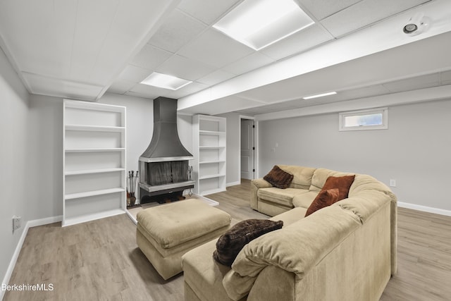 73 Narragansett Ave, Lanesborough, MA 01237 - living area with a wood stove, light wood-style flooring, built in features, and a paneled ceiling