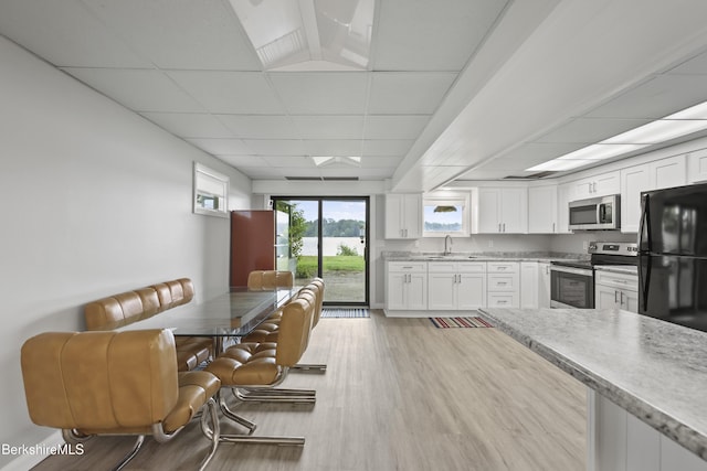 73 Narragansett Ave, Lanesborough, MA 01237 - kitchen featuring appliances with stainless steel finishes, light wood-style flooring, a paneled ceiling, white cabinets, and light stone countertops