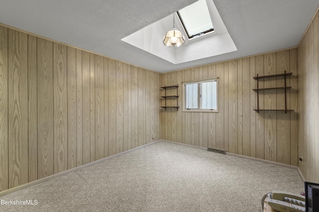 73 Narragansett Ave, Lanesborough, MA 01237 - carpeted spare room with a skylight, a textured ceiling, and wood walls