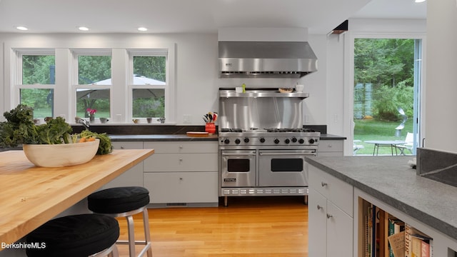 771 W Rd, Sheffield, MA 01257 - kitchen featuring wall chimney exhaust hood, double oven range, white cabinets, light wood-type flooring, and recessed lighting