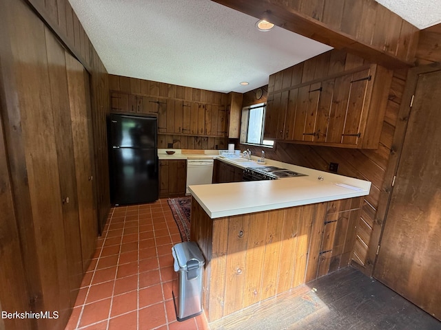841 Moberg Rd, Becket, MA 01223 - kitchen featuring freestanding refrigerator, a textured ceiling, dishwasher, wooden walls, and brown cabinets