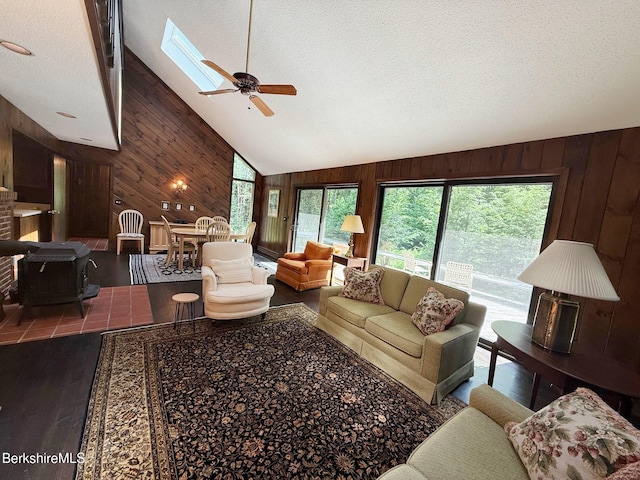 841 Moberg Rd, Becket, MA 01223 - living room featuring wooden walls, wood finished floors, a skylight, ceiling fan, and a textured ceiling