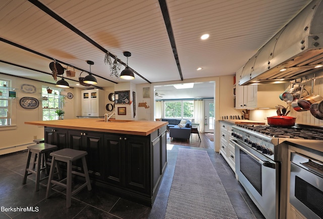 1 Train Hill Rd, Stockbridge, MA 01262 - kitchen with sink, a center island with sink, white cabinets, stainless steel stove, and butcher block counters