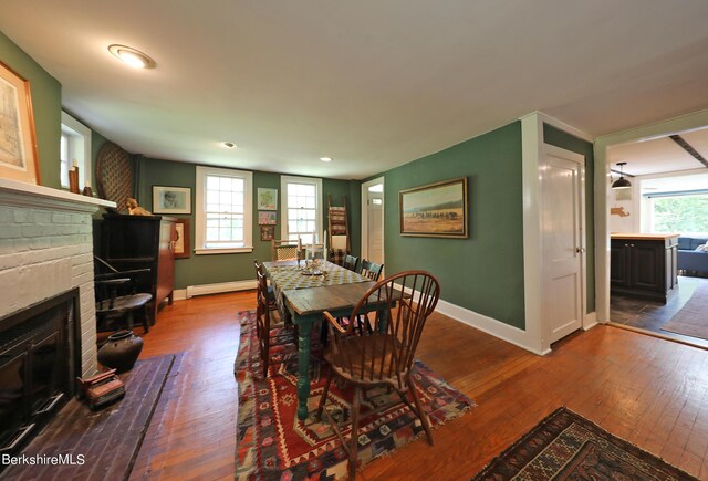 1 Train Hill Rd, Stockbridge, MA 01262 - dining room with hardwood / wood-style flooring, a baseboard heating unit, a wealth of natural light, and a brick fireplace