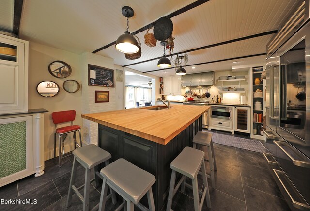 1 Train Hill Rd, Stockbridge, MA 01262 - kitchen with a breakfast bar, sink, butcher block countertops, wine cooler, and hanging light fixtures