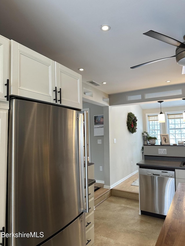 kitchen featuring visible vents, a ceiling fan, white cabinetry, appliances with stainless steel finishes, and pendant lighting