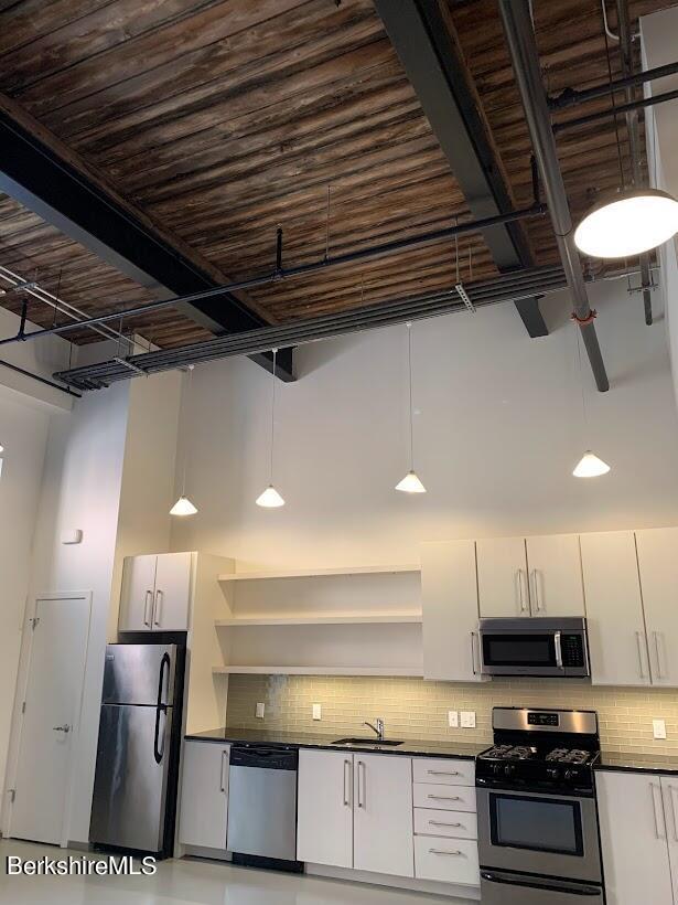 kitchen with white cabinetry, sink, decorative light fixtures, and appliances with stainless steel finishes