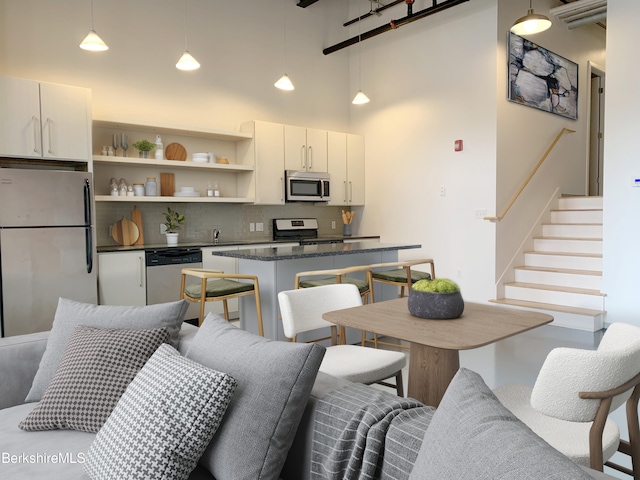 kitchen with white cabinets, white refrigerator, decorative light fixtures, and range with electric stovetop