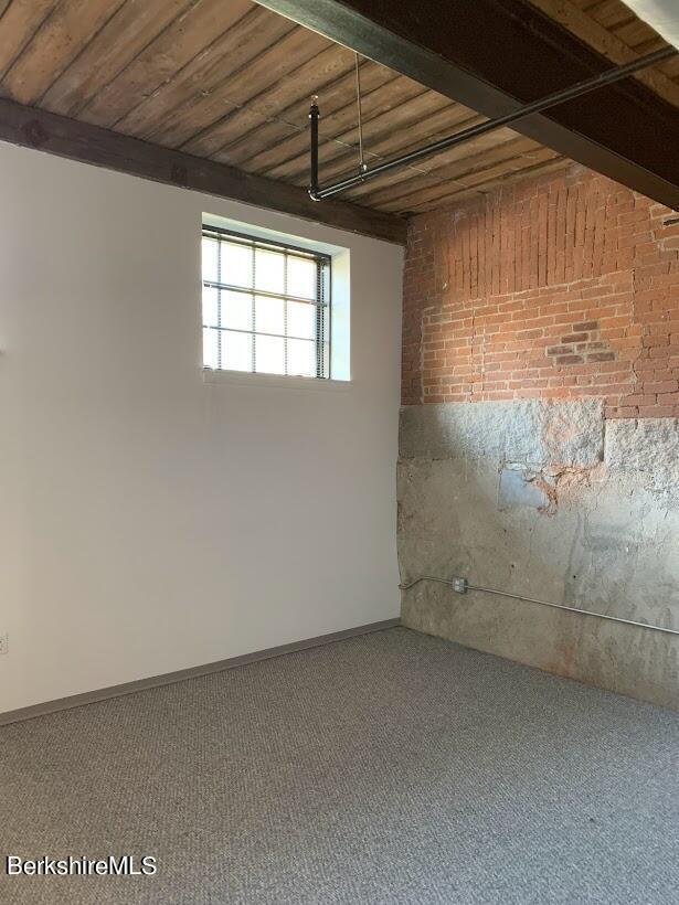 basement with carpet and wooden ceiling