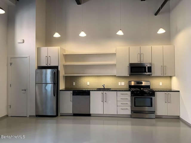 kitchen featuring decorative light fixtures, stainless steel appliances, and white cabinetry