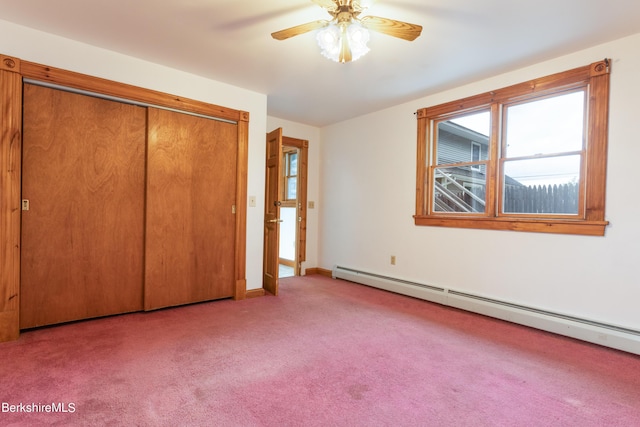 unfurnished bedroom featuring light colored carpet, a closet, a baseboard heating unit, and ceiling fan