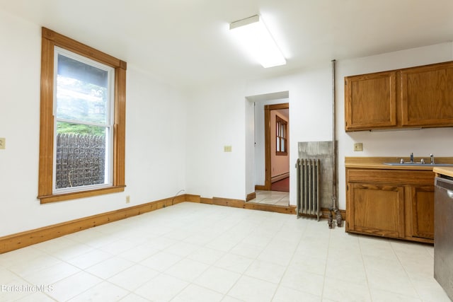 kitchen featuring stainless steel dishwasher, radiator heating unit, and sink