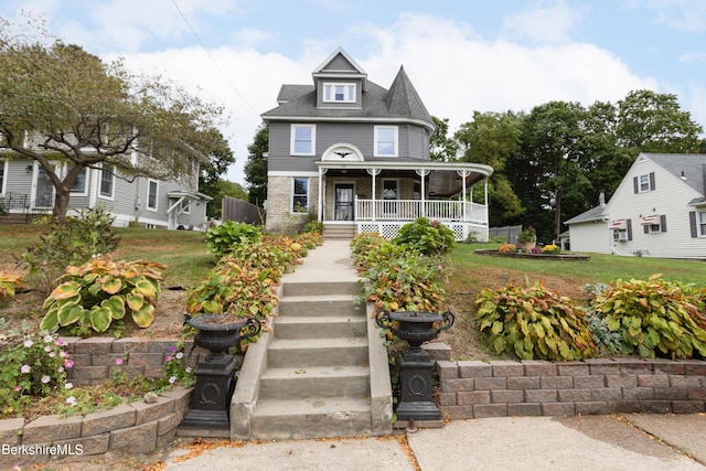 victorian-style house featuring a front lawn and covered porch