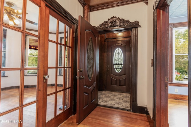 foyer with crown molding, french doors, and hardwood / wood-style floors