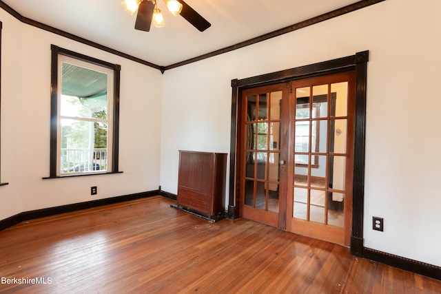 empty room featuring ceiling fan, french doors, wood-type flooring, and plenty of natural light