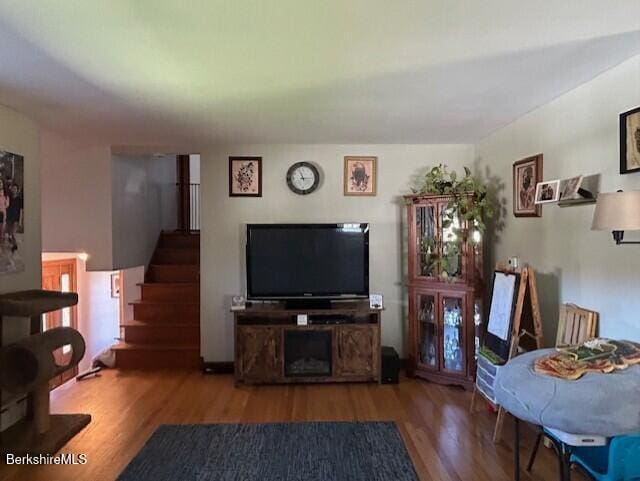 living room with wood finished floors and stairway