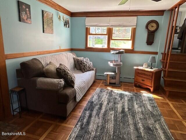 sitting room with a ceiling fan, a baseboard radiator, baseboard heating, and ornamental molding