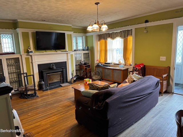 145 Bartlett Ave, Pittsfield, MA 01201 - living area featuring plenty of natural light, wood finished floors, ornamental molding, a fireplace with flush hearth, and a chandelier