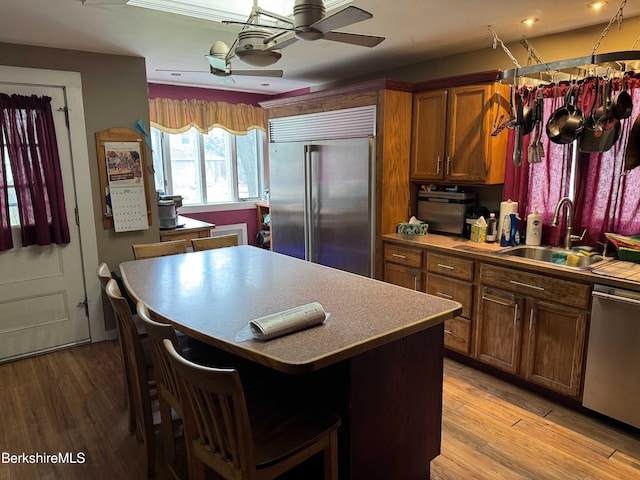 145 Bartlett Ave, Pittsfield, MA 01201 - kitchen with stainless steel appliances, a sink, a ceiling fan, a kitchen island, and brown cabinets