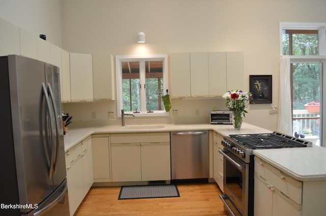 345 Big Bass Ln, Becket, MA 01223 - kitchen featuring stainless steel appliances, light countertops, a peninsula, light wood finished floors, and a towering ceiling