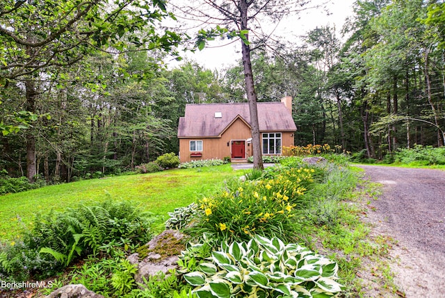 345 Big Bass Ln, Becket, MA 01223 - rustic home with a chimney, a shingled roof, gravel driveway, and a wooded view