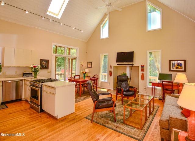 345 Big Bass Ln, Becket, MA 01223 - kitchen featuring stainless steel appliances, high vaulted ceiling, rail lighting, light wood-style flooring, and a peninsula