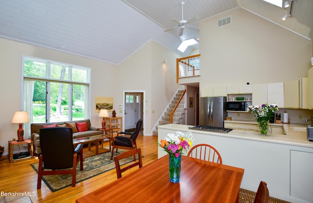 345 Big Bass Ln, Becket, MA 01223 - dining room featuring high vaulted ceiling, light wood-type flooring, stairs, and a ceiling fan
