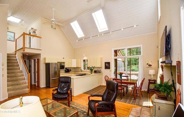 345 Big Bass Ln, Becket, MA 01223 - living room with a skylight, high vaulted ceiling, stairs, a ceiling fan, and wood finished floors