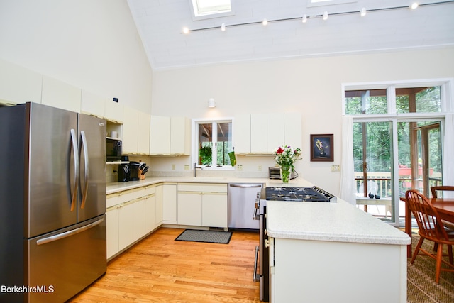 345 Big Bass Ln, Becket, MA 01223 - kitchen with appliances with stainless steel finishes, high vaulted ceiling, light countertops, a peninsula, and light wood-style flooring