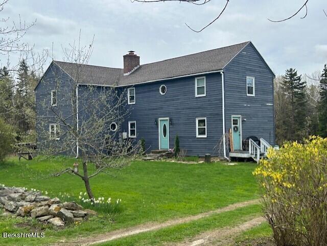 rear view of property with a yard