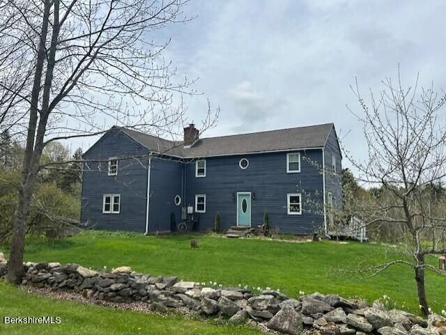 rear view of house with a yard