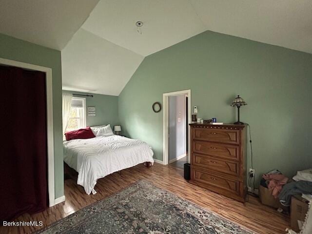 bedroom featuring hardwood / wood-style flooring and vaulted ceiling