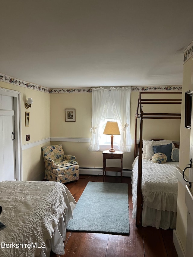 bedroom with a baseboard radiator and dark wood-type flooring