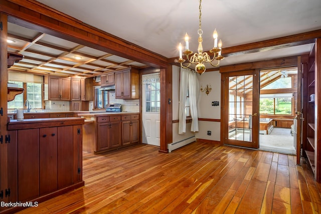 kitchen with coffered ceiling, hanging light fixtures, decorative backsplash, baseboard heating, and a chandelier