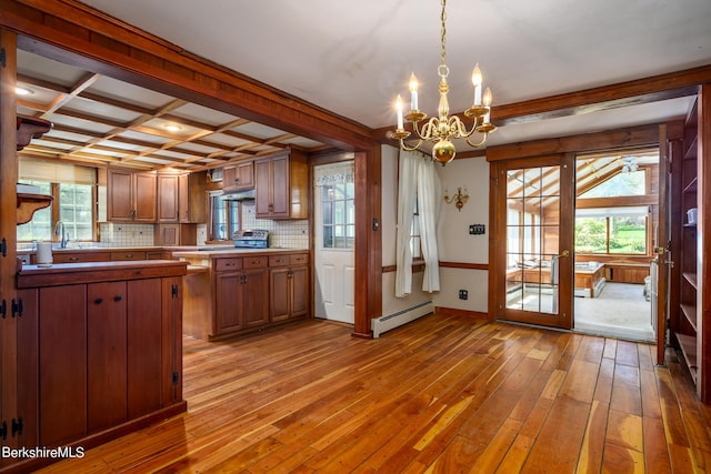 1151 Hancock Rd, Williamstown, MA 01267 - kitchen featuring a baseboard heating unit, light wood-type flooring, a chandelier, under cabinet range hood, and brown cabinetry