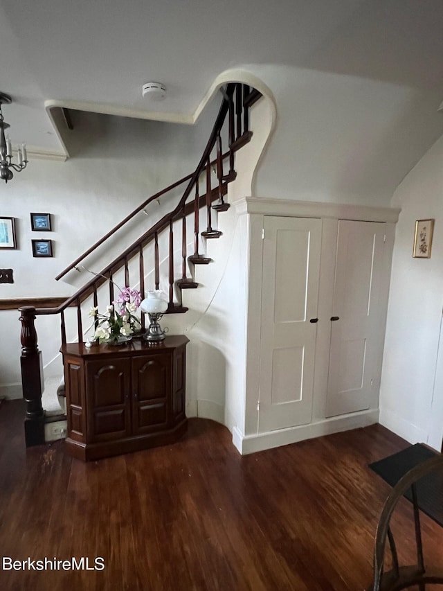 staircase featuring hardwood / wood-style floors and a notable chandelier