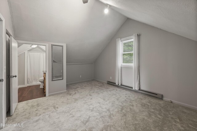 94 Corey Rd Unit D, Hancock, MA 01237 - additional living space featuring a baseboard heating unit, carpet flooring, a textured ceiling, vaulted ceiling, and baseboards