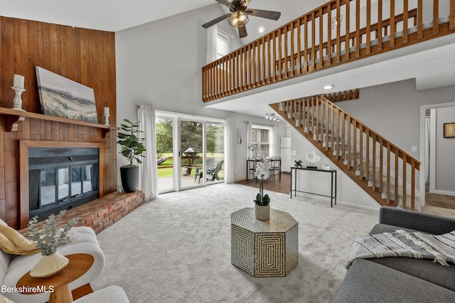94 Corey Rd Unit D, Hancock, MA 01237 - carpeted living room featuring stairs, a brick fireplace, a ceiling fan, a high ceiling, and baseboards