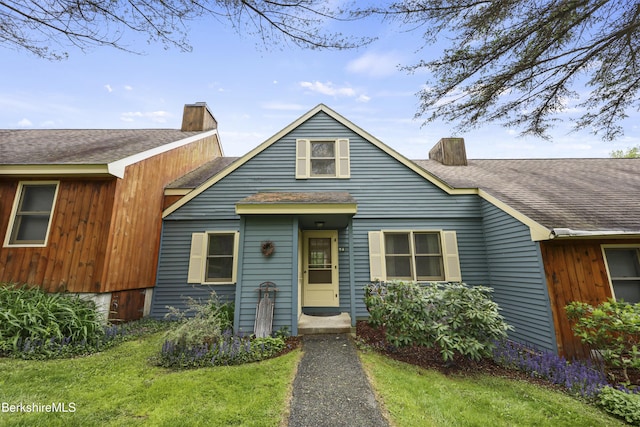 94 Corey Rd Unit D, Hancock, MA 01237 - view of front of house featuring a chimney, roof with shingles, and a front lawn