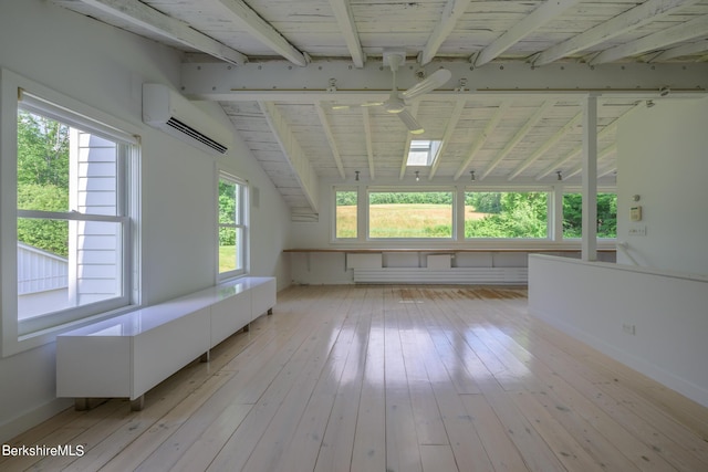 additional living space with a wall mounted air conditioner, light wood-type flooring, plenty of natural light, and ceiling fan