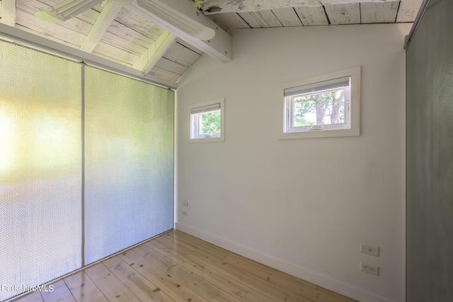 empty room with vaulted ceiling with beams, light wood-type flooring, and wood ceiling