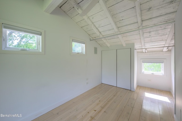 unfurnished bedroom featuring lofted ceiling with beams, light hardwood / wood-style flooring, a closet, and wood ceiling