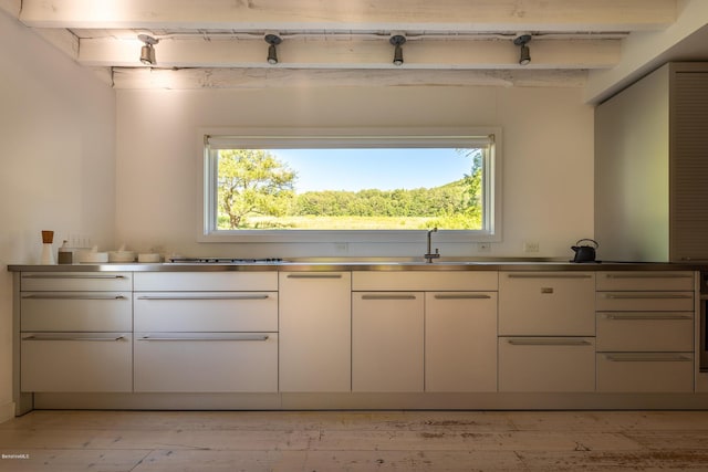 kitchen featuring beam ceiling, plenty of natural light, and sink